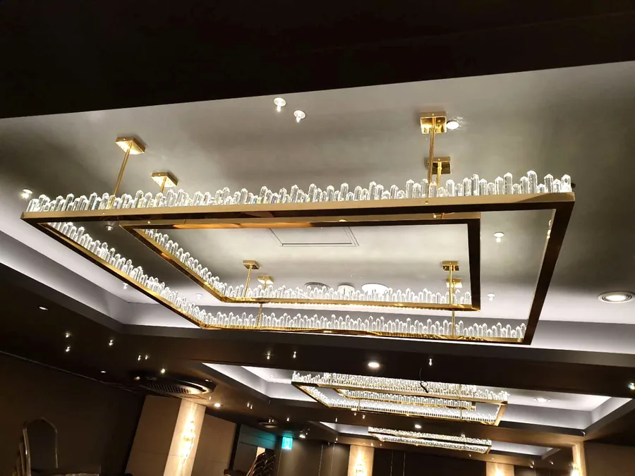 Hotel ballroom — gold rectangular crystal chandeliers receding down the ceiling