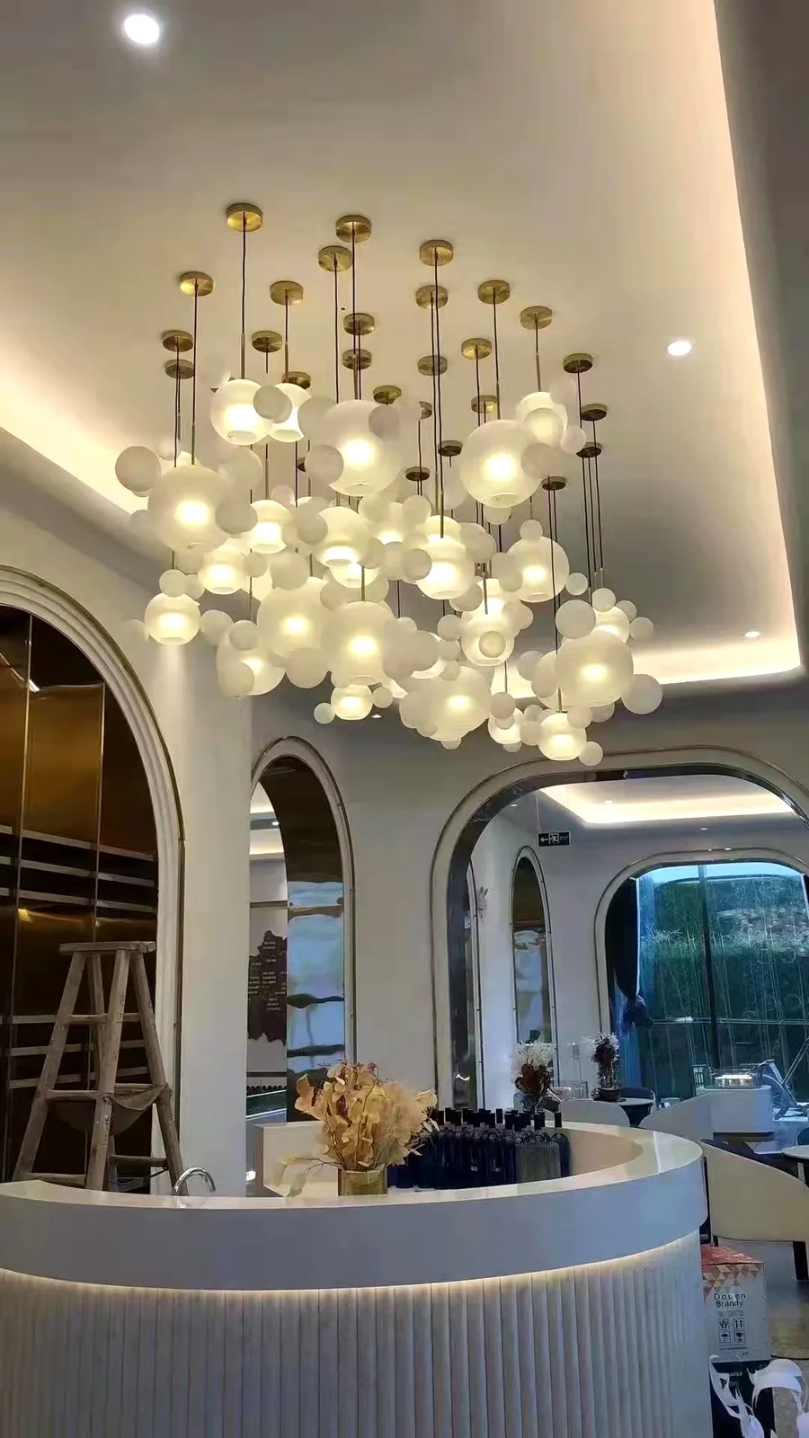 Cloud of frosted glass bubble pendants above a café counter