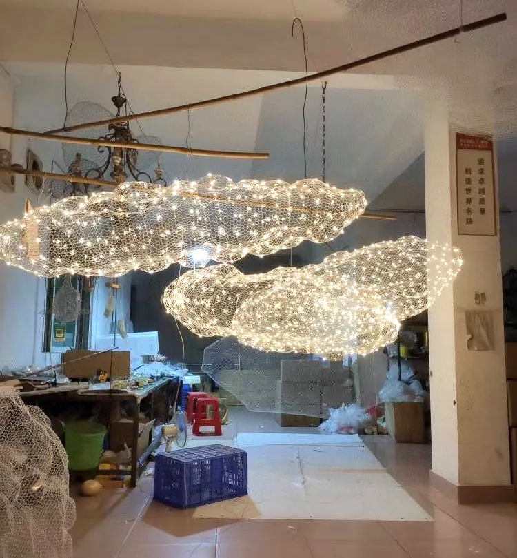 Cloud-shaped mesh light sculptures hanging in our Guzhen workshop during assembly and lit test